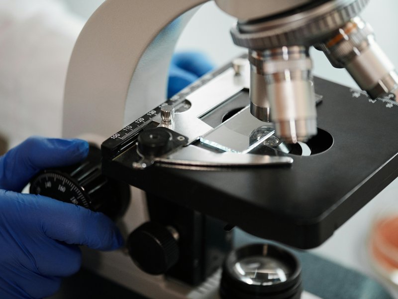 Ricercatrice al microscopio in laboratorio, simbolo di nanotecnologia